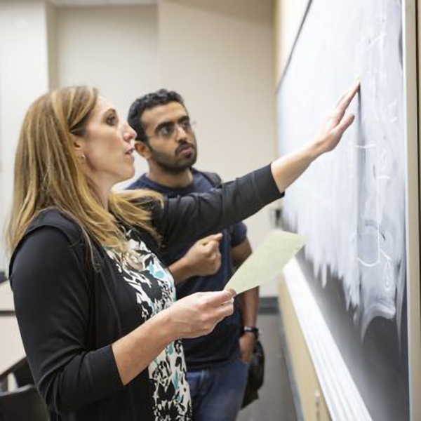 Faculty Helping student on chalkboard
